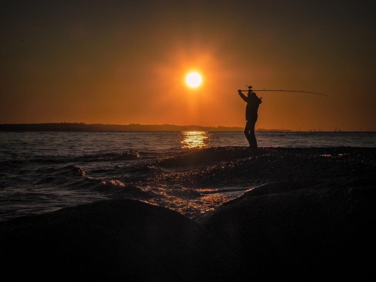 En mand fisker i havet i Nordsjælland ved Øresund på Kronborg Strand