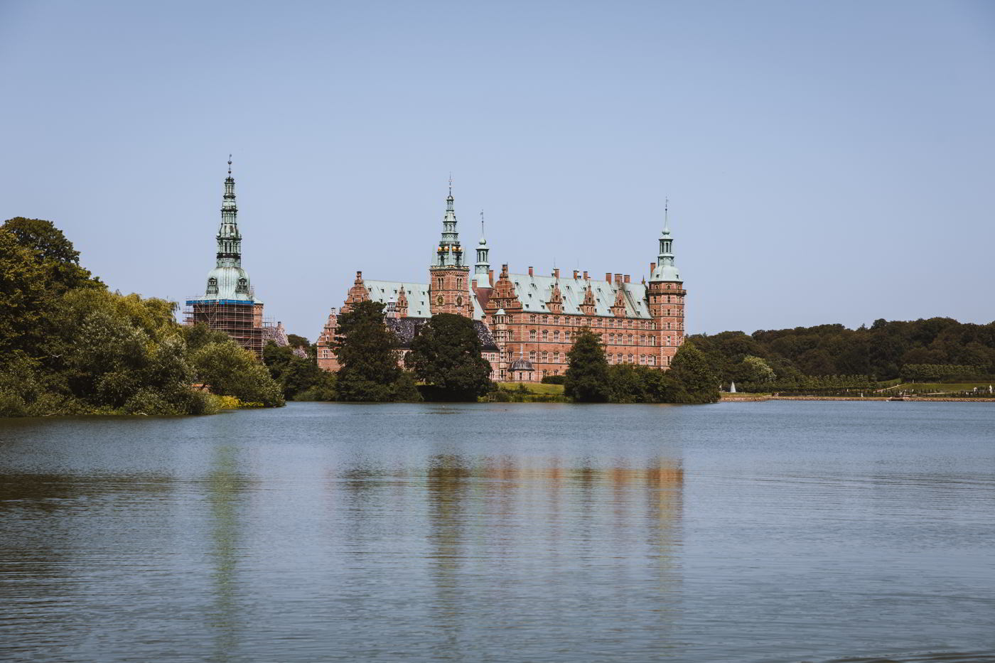 Frederiksborg Castle with the castle lake in front, as seen from the Square in Hillerød on a summer day.