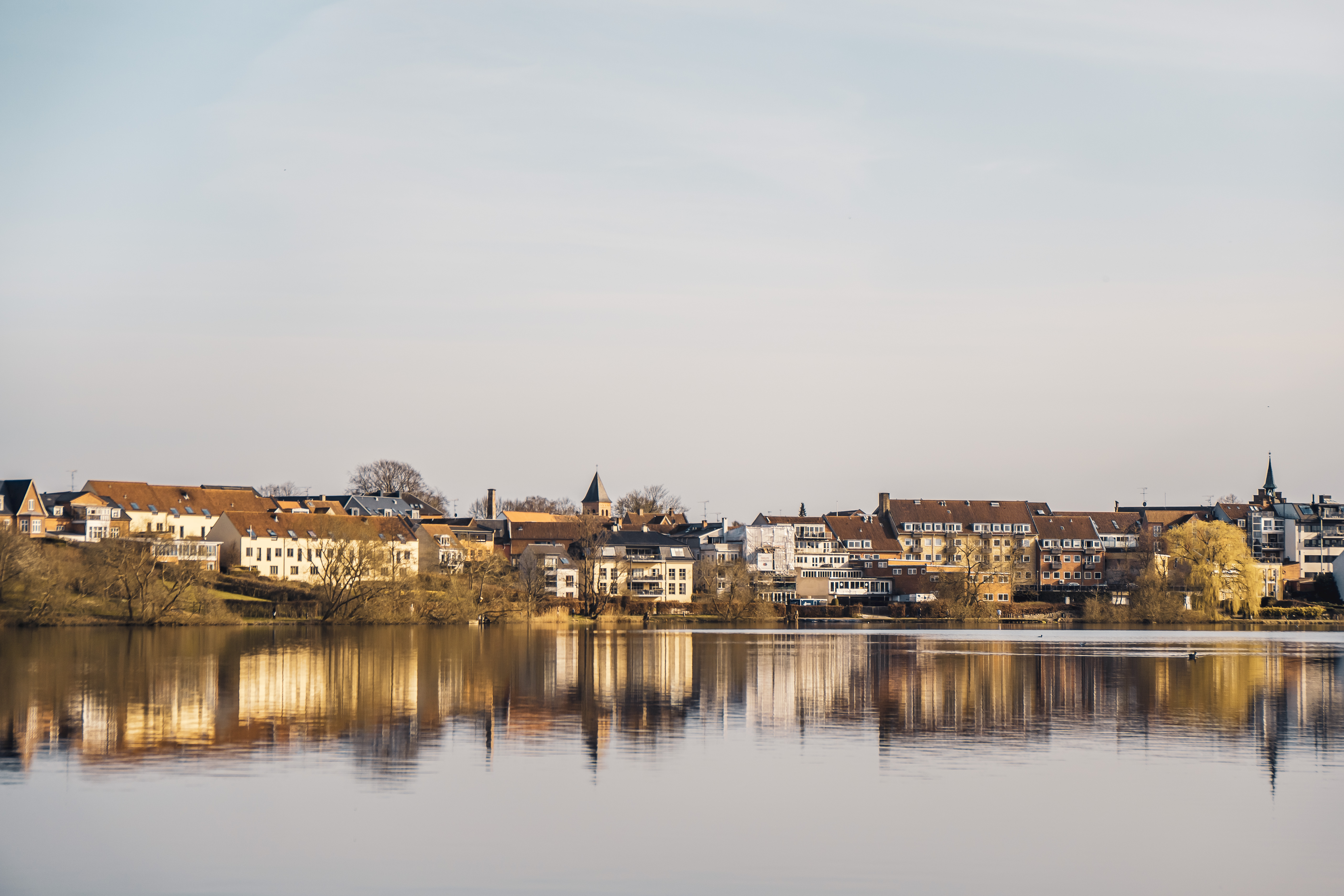 Solen skinner gyldent på husene i Hillerød set fra Slotssøen