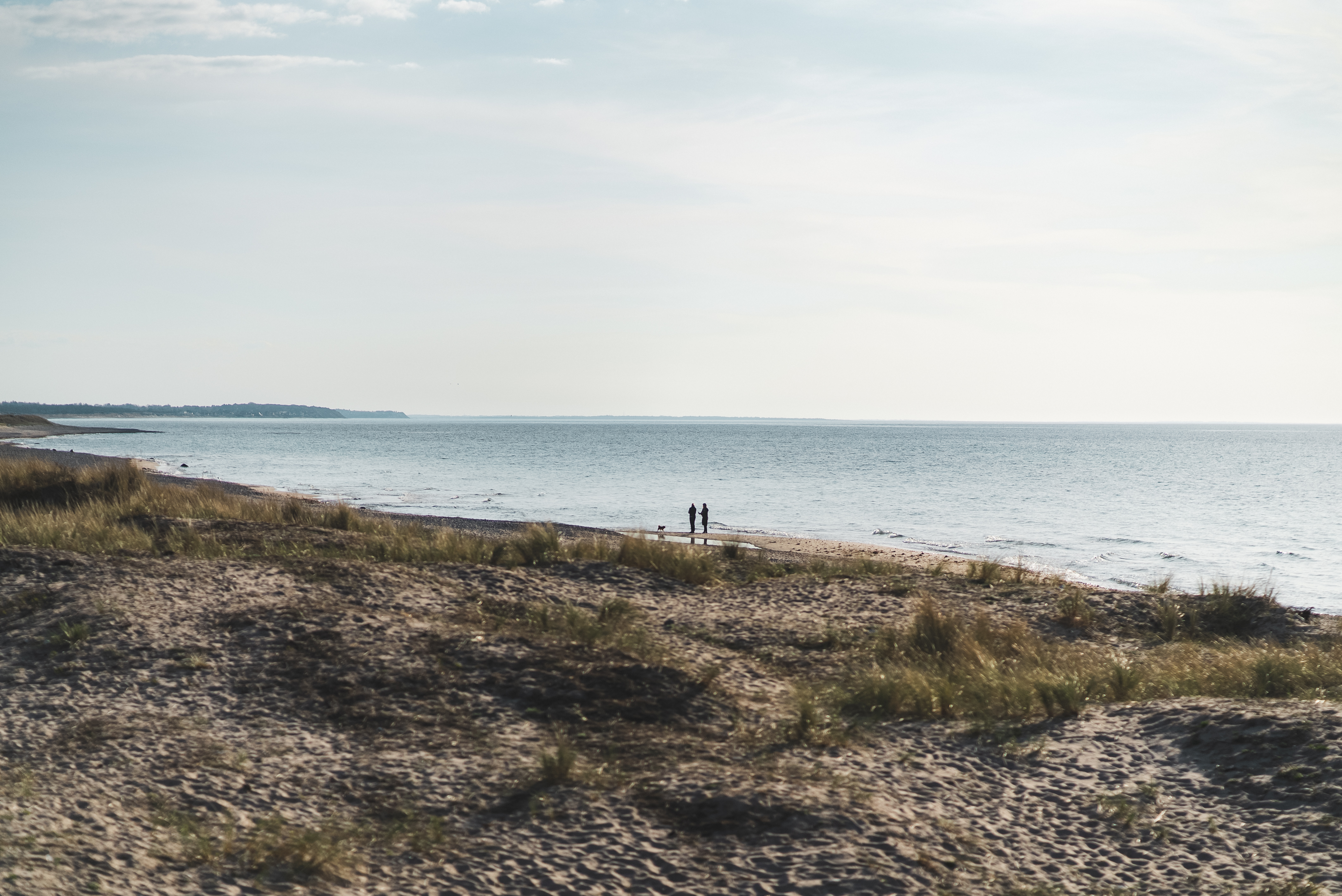 To mennesker går en tur på Tisvildeleje Strand