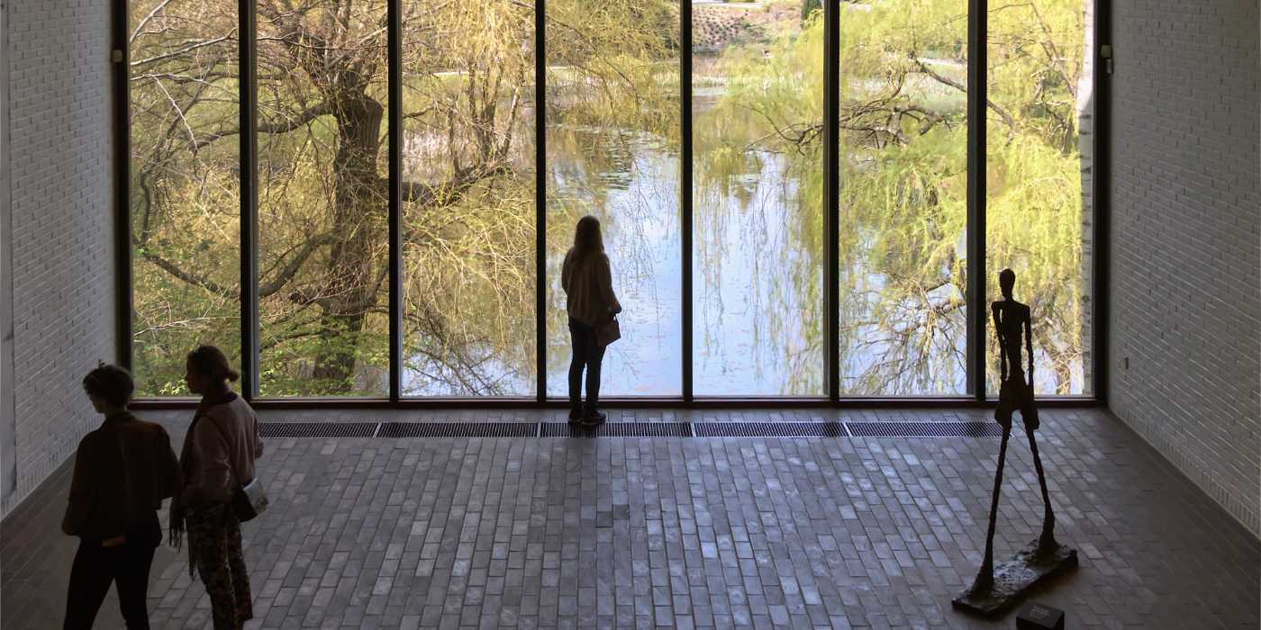 Kvinde ser ud over søen ved Louisiana Museum of Modern Art