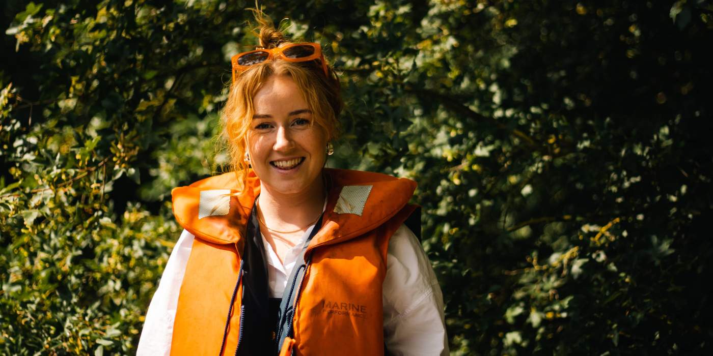 En kvinde står i redningsvest parat til at stige ned i sin kajak