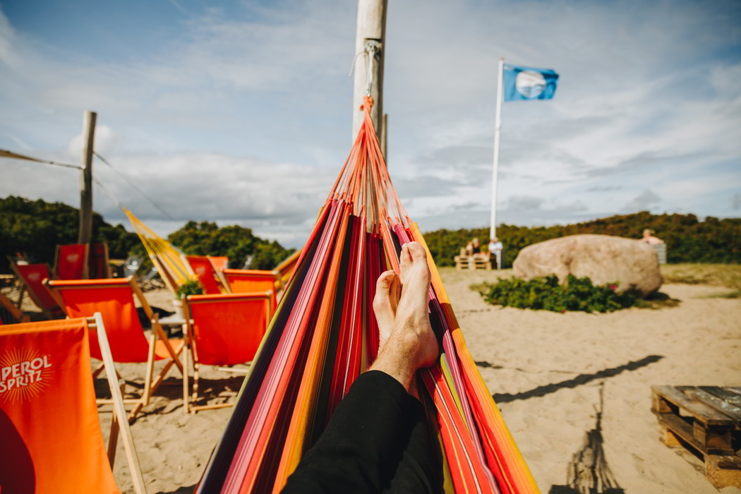 Person der ligger i en hængekøje på stranden