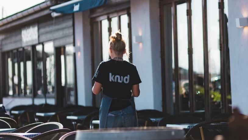 A waiter is ready to serve in the morning sun on the terrace outside the Knud eatery in Hundested.